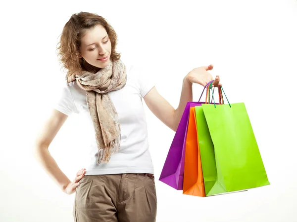 Beautiful young woman holding multicolored paper bags — Stock Photo, Image