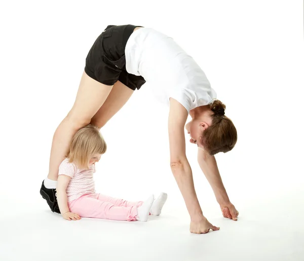 Mladá žena, která dělá sportovní cvičení se svou malou dcerou — Stock fotografie