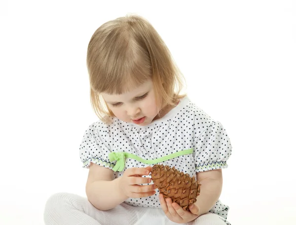 Menina brincando com cone de cedro — Fotografia de Stock