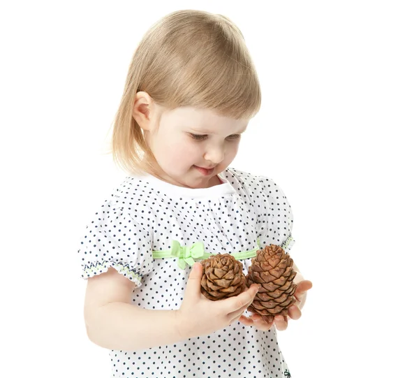 A menina sorridente segurando cones de cedro — Fotografia de Stock