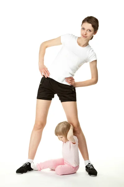 Giovane madre e piccola figlia che esercita — Foto Stock