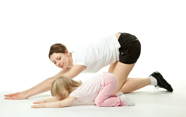 Mãe feliz fazendo exercícios esportivos com sua filhinha — Fotografia de Stock