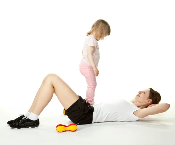 Young mother doing sport exercises with her little daughter — Stock Photo, Image