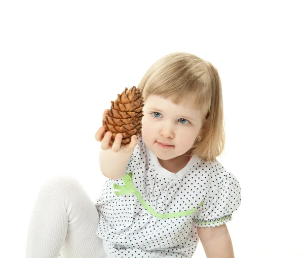 Malá dívka si hraje s cedar kužel — Stock fotografie