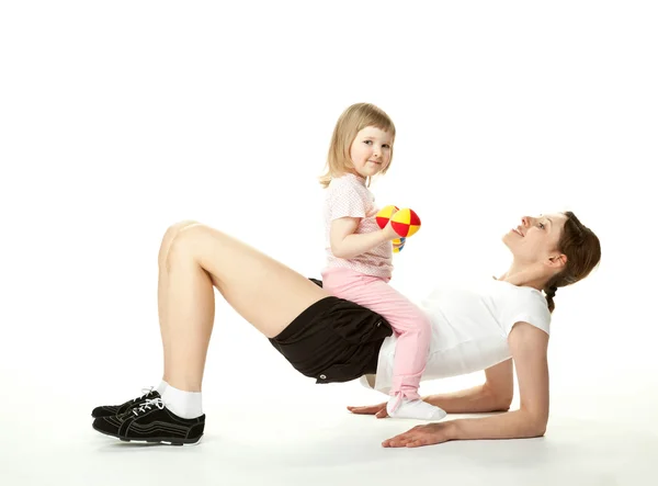 Mladá matka dělá sportovní cvičení s dcerou — Stock fotografie