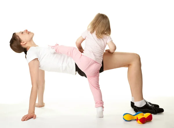 mutlu genç bir kadın ve kızı spor egzersizleri yapıyor