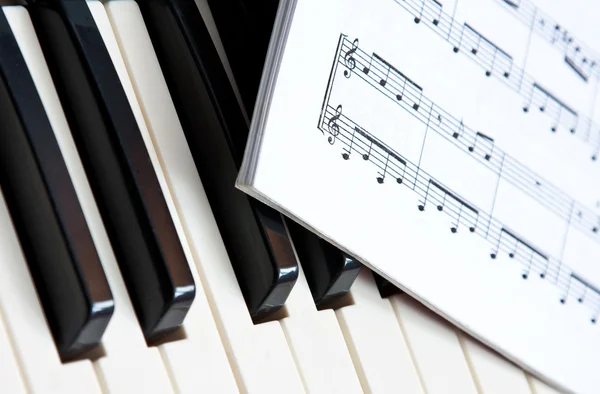 ピアノの鍵盤の上に横たわる音楽本 — ストック写真