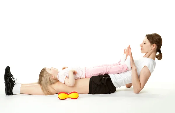 Young mother doing sport exercises with her little daughter — Stock Photo, Image