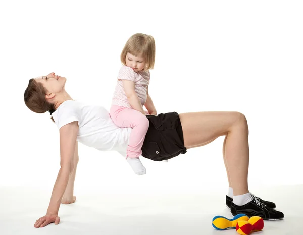 Jovem mãe fazendo exercícios esportivos com sua filha — Fotografia de Stock