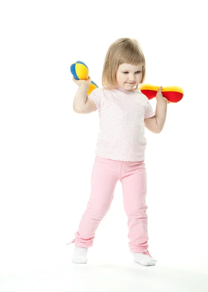 Милая маленькая девочка делает спортивные упражнения с игрушечными гантелями — стоковое фото
