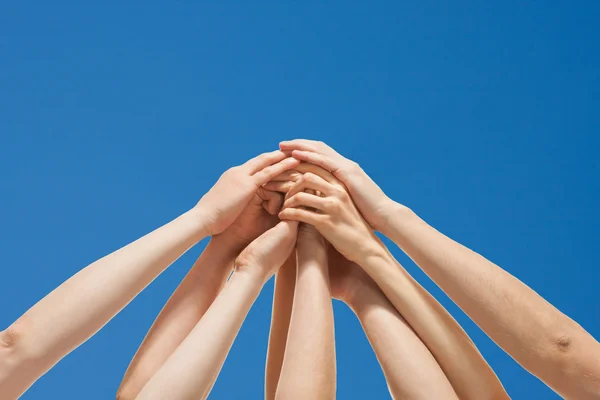 Successful team: many hands holding together on blue background — Stock Photo, Image