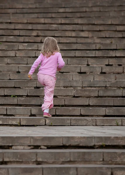 Vacker liten flicka gå på övervåningen — Stockfoto