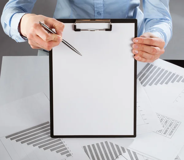 Hand pointing at blank paper in clipboard with a pen — Stock Photo, Image