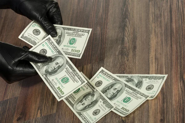 Человеческие руки в черных перчатках с долларами — стоковое фото