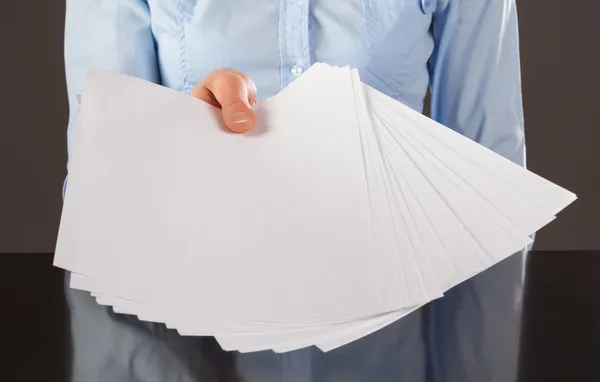 Mão estendendo documentos em branco — Fotografia de Stock