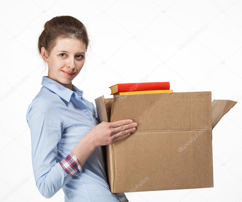 Smiling woman carrying a box with books
