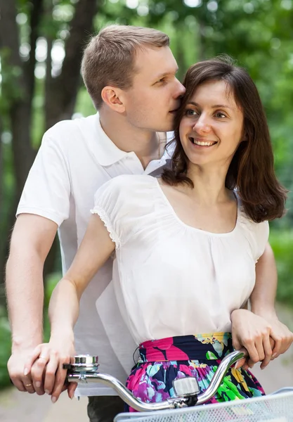 Happy young couple walking with bicycles — Stock Photo, Image