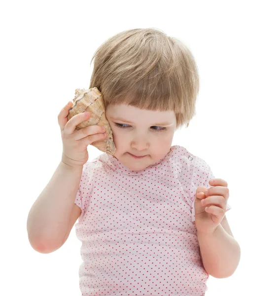 Menina bonito brincando com uma concha — Fotografia de Stock