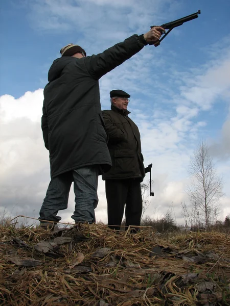 Men shooting in rural area — Stock Photo, Image