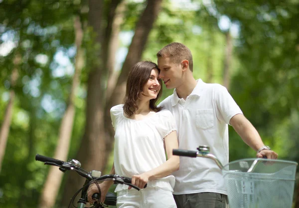 Romantico giovane coppia a piedi con biciclette — Foto Stock