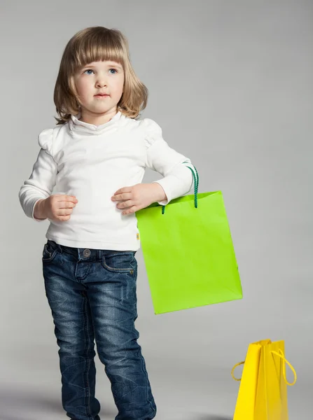 Leende liten flicka håller shopping väska — Stockfoto