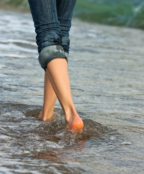 Woman's legs walking along the seacoast — Stock Photo, Image
