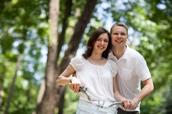 Heureux jeune couple marchant à vélo — Photo