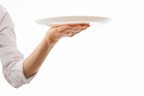 Человеческая рука с белой тарелкой — стоковое фото