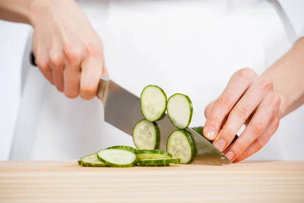 Female hands cutting fresh cucumber — Stock Photo, Image