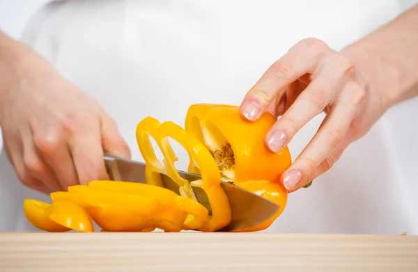 Vrouwelijke handen snijden verse peper — Stockfoto