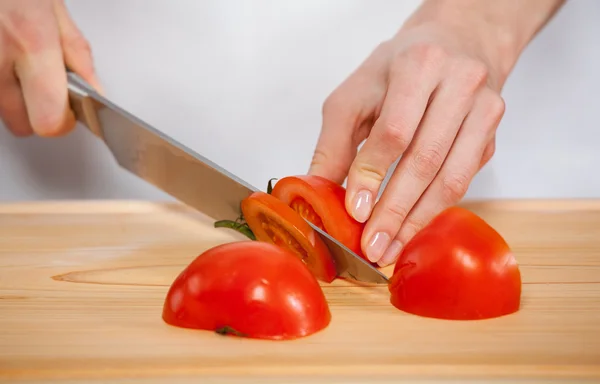 Female hands cutting fresh tomato — Stock Photo, Image