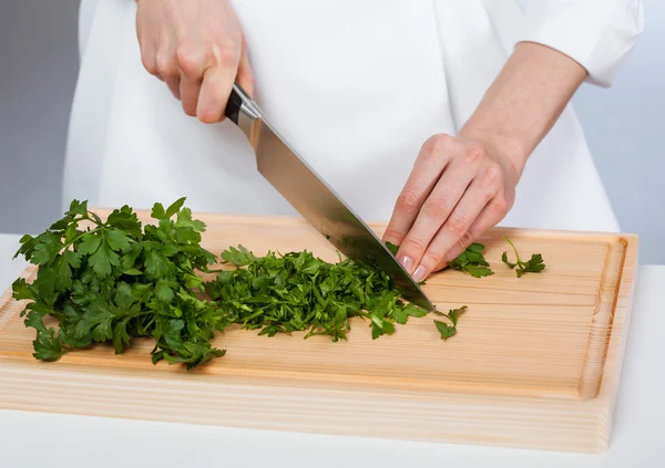 Cook chopping fresh parsley — Stock Photo, Image