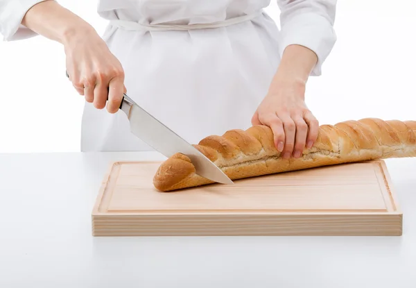 Cook cutting bread on wooden board — Stock Photo, Image