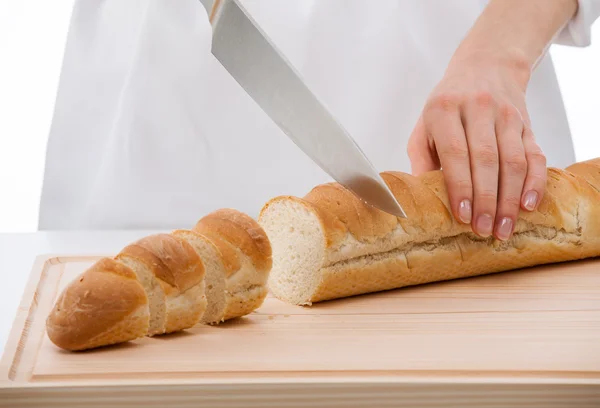 Cutting bread on wooden board — Stock Photo, Image