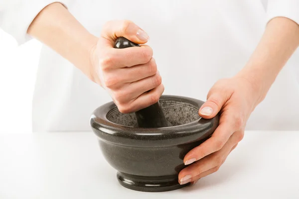 Cook's hands pounding something using mortar and pestle — Stock Photo, Image