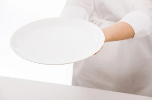 Woman's hands holding white plate — Stock Photo, Image
