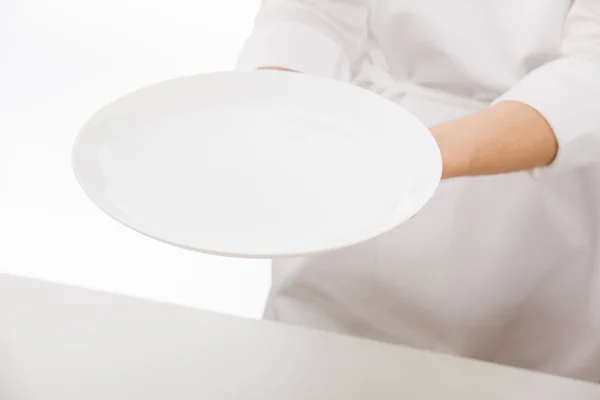 Woman's hands holding white plate — Stock Photo, Image