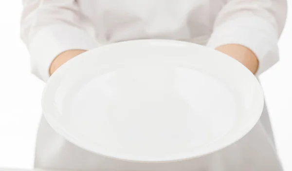 Женские руки с белой тарелкой — стоковое фото