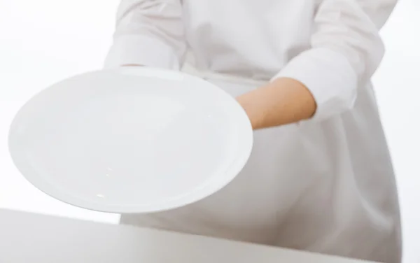 Woman's hands holding an empty plate — Stock Photo, Image