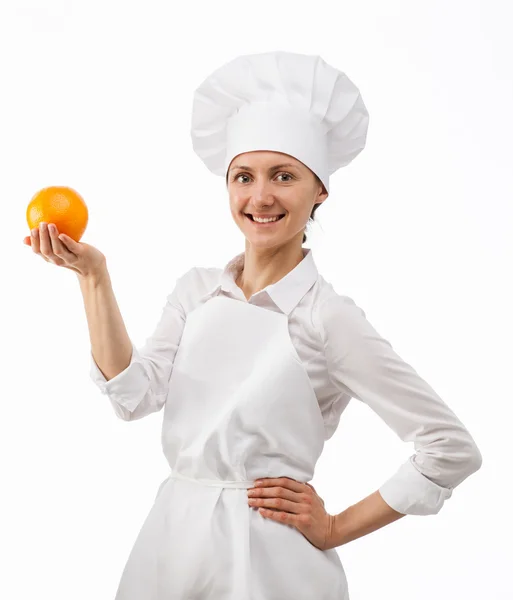 Beautiful young female cook showing an orange — Stock Photo, Image