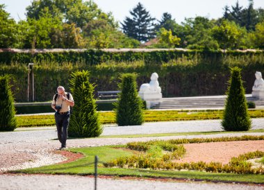 Tourist walking along the garden of Belvedere clipart