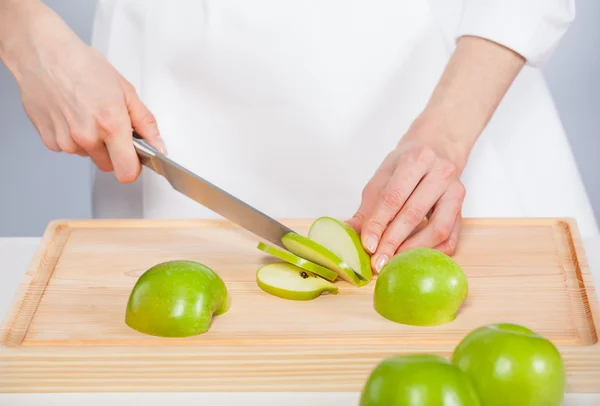 Las manos del cocinero cortan manzana verde fresca — Foto de Stock