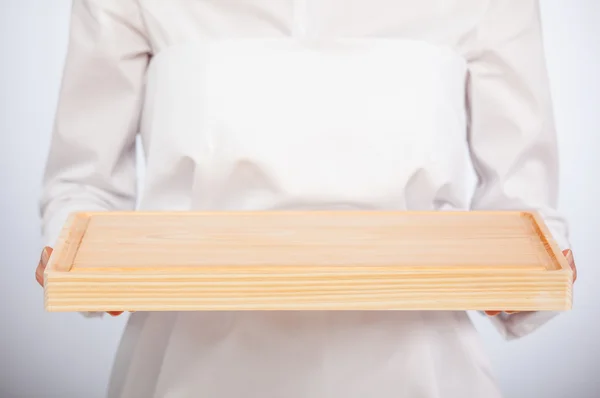 Женщина-повар держит деревянную доску — стоковое фото