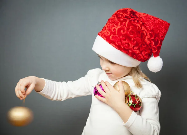 Portrét okouzlující holčička v santa klobouk — Stock fotografie