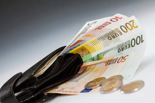 Банкноты евро в кожаном кошельке и монетах — стоковое фото