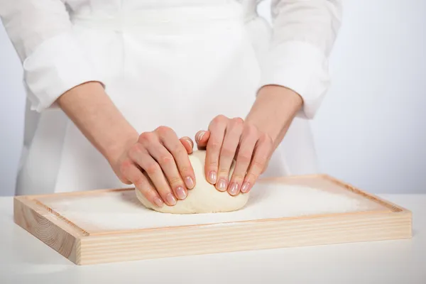 Mains de cuisinier pétrissant la pâte — Photo