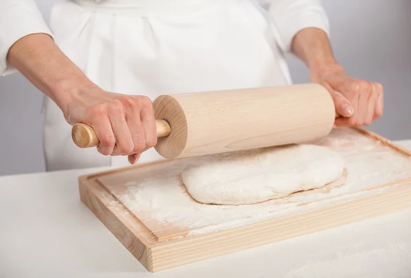 Cook's hands rolling out dough — Stock Photo, Image