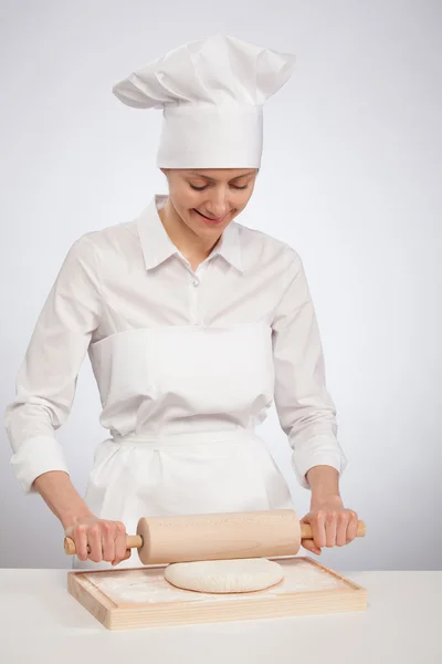 Smiling female cook rolling dough out — Stock Photo, Image