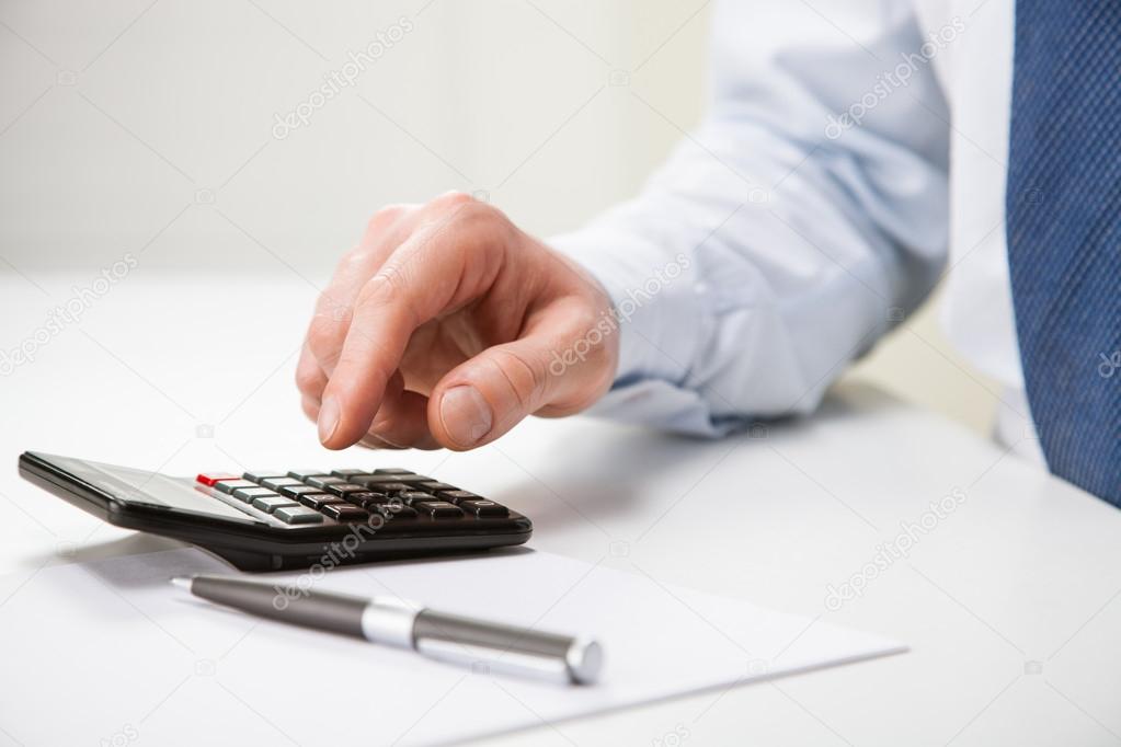 Hand of businessman using a calculator