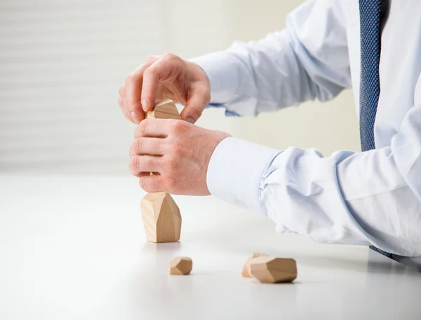 Geschäftsmann fertigt Turm aus Holzklötzen — Stockfoto